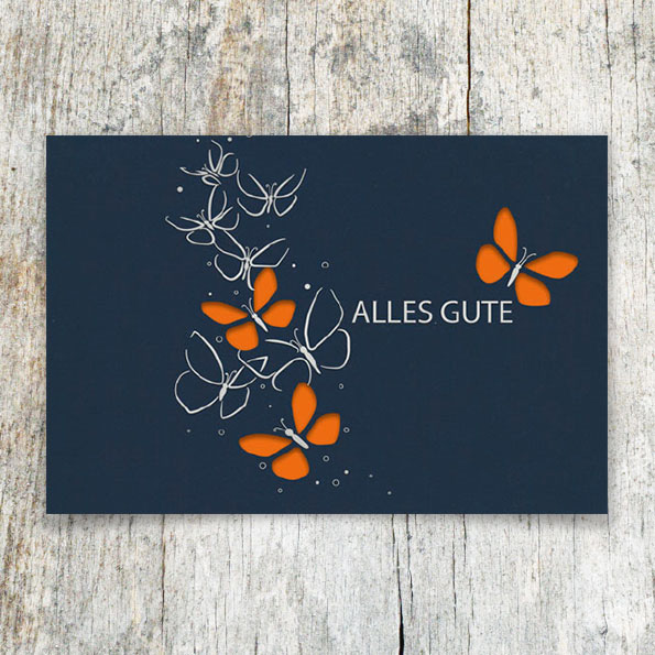 Vergrößerte Abbildung Dunkelblaue Glückwunschkarten mit Silberprägung, ausgestanzten Schmetterlingen und farbigem Einlegeblatt in Orange