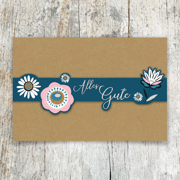 Vergrößerte Abbildung Glückwunschkarte aus braunem Kraftkarton mit blauer Banderole, Blumenmotiv und silbergeprägtem Schriftzug Alles Gute